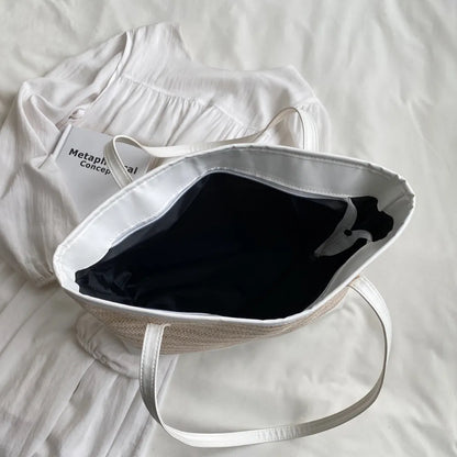 Bolsa de mão com alça de couro e detalhes em palha