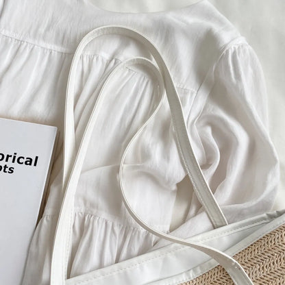 Bolsa de mão com alça de couro e detalhes em palha