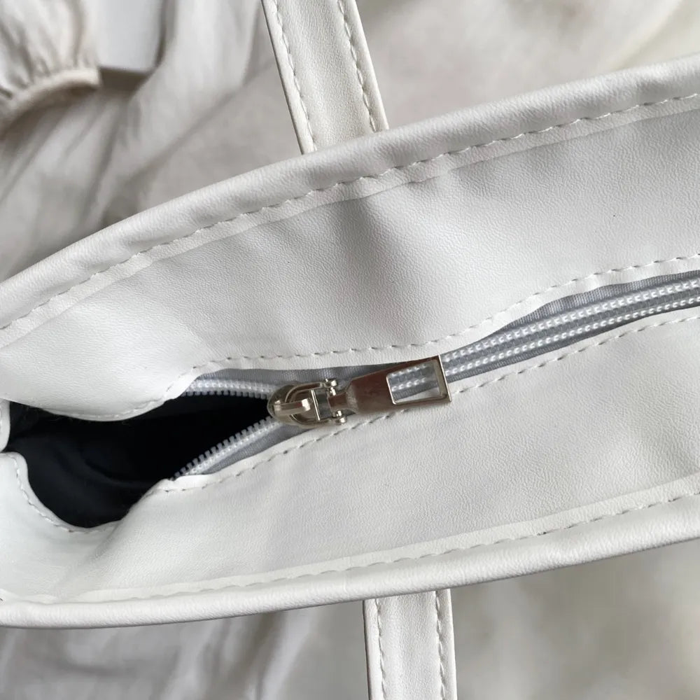 Bolsa de mão com alça de couro e detalhes em palha